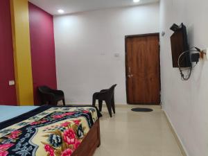 a bedroom with a bed and a wooden door at R K Guest House Arpora in Mapusa