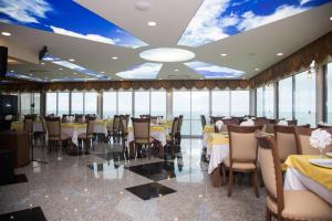 ホパにあるNana Hotelの海の景色を望むテーブルと椅子付きのレストラン