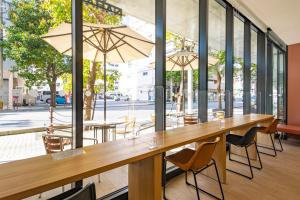 a long table in a restaurant with chairs and umbrellas at NAHA-WEST INN in Naha +90 photos