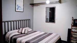 a small bedroom with a bed and a mirror at Hotel Coyoacan in Mexico City