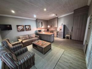 a living room with a couch and a table and a kitchen at Drinkwater Guest Farm in Grootgewaagd