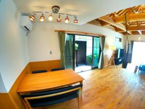 a dining room with a wooden table and chairs at CARA-YA(かーらやー） in Ishigaki Island