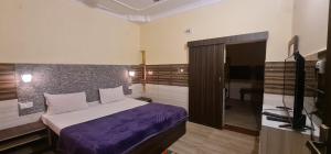 a bedroom with a bed and a television in it at Hotel Vijay in Rājgīr
