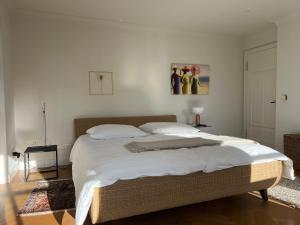 a bedroom with a large bed with white sheets at Herrenhaus - Starnberger See - Ammerland in Münsing