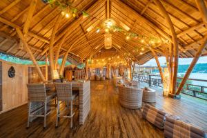 a restaurant with a wooden ceiling and tables and chairs at Nusa View - Oceanfront Rentals in Nusa Lembongan