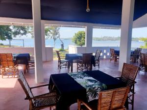 a dining room with tables and chairs and a view of the water at Newdarling beach hotel in Watamu
