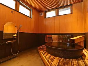 a bathroom with a large bath tub and windows at Taiyokan in Minakami