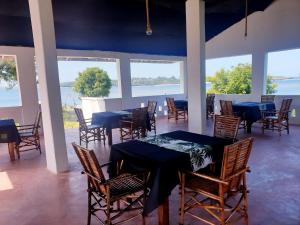 a dining room with blue tables and chairs at Newdarling beach hotel in Watamu