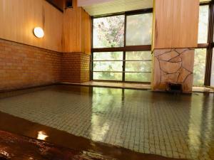 an empty room with a tile floor and windows at Taiyokan in Minakami