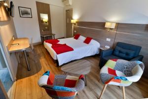 a bedroom with a bed and two chairs and a table at Hôtel de l'Europe Grenoble hyper-centre in Grenoble