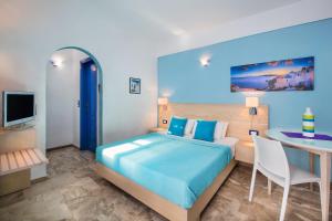 a bedroom with a bed and a table and a desk at Samson΄s Village in Perissa