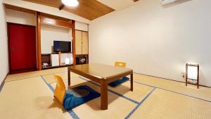 a living room with a table and a chair at Taiyokan in Minakami
