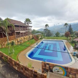 an image of a swimming pool in front of a house at Grand Pujon View in Songgoriti