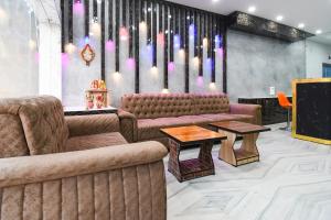 a lobby with couches and a stage with lights at Hotel O Radha Krishna Residency in Nagri