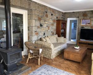 a living room with a couch and a stone wall at Hills Manor House in Greenmount