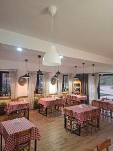 a restaurant with red and white tables and chairs at Fruškogorski Đeram in Grgeteg