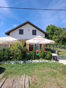 a house with two umbrellas in front of it at Fruškogorski Đeram in Grgeteg