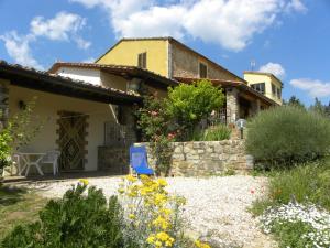 a house with a blue chair in front of it at Agriristoro Podere S. Andrea in Massa Marittima