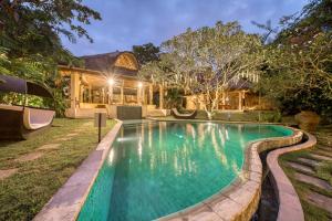 a swimming pool in the backyard of a house at Nomadic Resort Bali in Canggu
