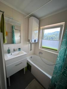 a bathroom with a sink and a tub and a window at Ferien am Bischofsberg - Edlbach 31 in Windischgarsten +22 photos