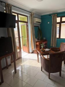 a living room with a table and a tv at Résidence Padma in Flic-en-Flac
