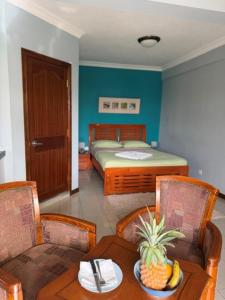 a bedroom with a bed and a table with a bowl of fruit at Résidence Padma in Flic-en-Flac +48 photos