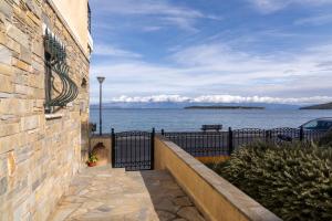 a building with a fence and a view of the water at The litlle mermaid in Amaliapoli