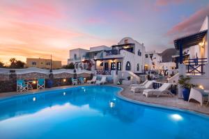 a villa with a swimming pool in front of a house at Samson΄s Village in Perissa