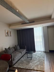 a living room with a couch and a large window at Enzo Stay -The Matrix 505 , Century City in Cape Town