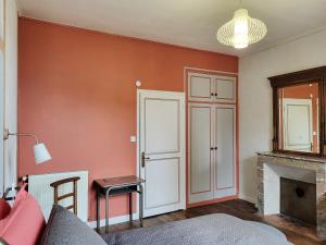 a living room with red walls and a fireplace at Une nuit à la Clouère in Saint-Maurice-la-Clouère
