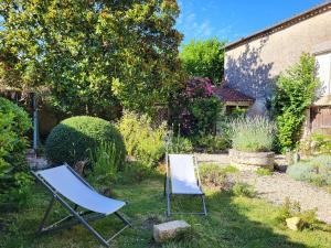 two chairs sitting in the grass in a garden at Une nuit à la Clouère in Saint-Maurice-la-Clouère