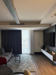 a living room with a couch and a flat screen tv at Enzo Stay -The Matrix 505 , Century City in Cape Town