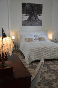 een slaapkamer met een bed en een tafel met een lamp bij L'Angulus Ridet in Porto Cesareo