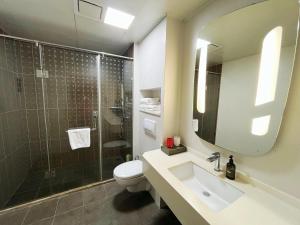 a bathroom with a toilet and a sink and a shower at Ibis Yixing Longbeishan Forest Park in Yixing