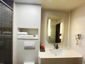 a bathroom with a sink and a mirror at Ibis Yixing Longbeishan Forest Park in Yixing