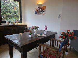 a dining room with a wooden table with flowers on it at Smart Rooms in Molinella
