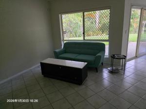 a living room with a green couch and a coffee table at Gaven Garden in Gold Coast