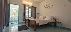 a bedroom with a bed in a room with a window at Yog Inn in Varkala