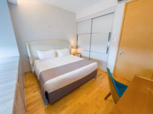 a bedroom with a bed and a table and a chair at UHF HOTELS and RESORTS PINETREE in Iskandar Puteri +72 photos