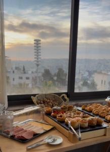 a bunch of donuts on a counter in front of a window at Weibdeh Heights Hotel Suites in Amman