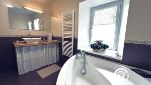 a bathroom with a tub and a sink and a window at Le moulin de camelière in Caudebronde +47 photos