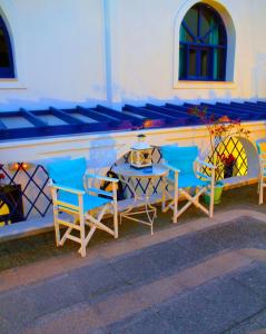 a group of chairs and a table in front of a building at Samson΄s Village in Perissa