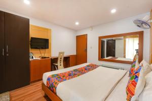 a bedroom with a bed and a desk and a television at FabHotel Upstream Mysore Road in Bangalore