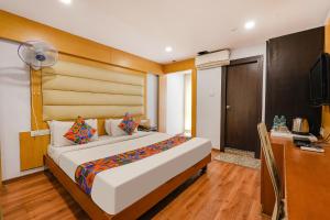 a bedroom with a bed and a desk and a television at FabHotel Upstream Mysore Road in Bangalore