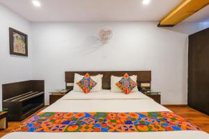 a bedroom with a bed with a colorful comforter at FabHotel Upstream Mysore Road in Bangalore +52 photos