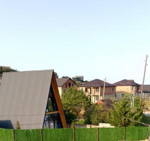 a house with a metal roof on top of a fence at Qusar a-freym in Qusar