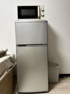 a microwave sitting on top of a refrigerator at Bon House Tokyo Private Luxury Retreat with Free Parking Reservation Required in Tokyo