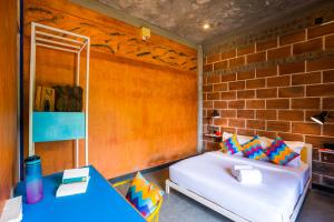 a bedroom with a bed and a brick wall at goSTOPS Pondicherry Near Auroville in Auroville +38 photos