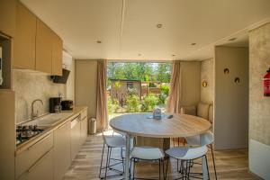 a kitchen with a table and chairs in a kitchen at Camping Les Pins - Bord de mer in Argelès-sur-Mer