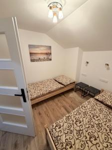 a room with two beds and a door at Prázdninový dům Centrum Pastvinská přehrada in Nekoř
